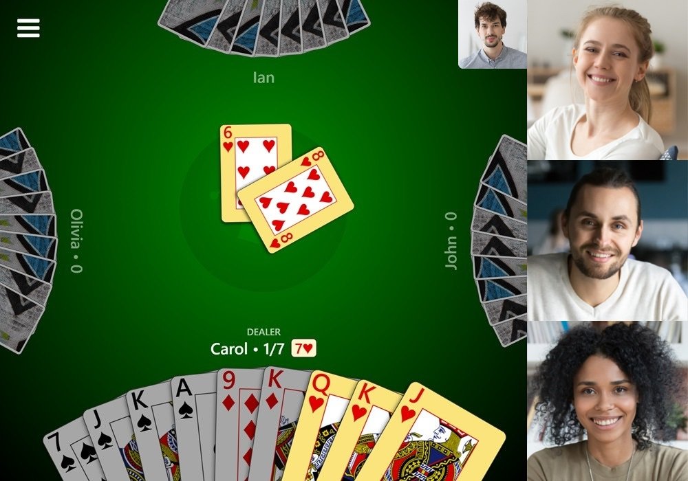 Screenshot of a game of 500 with video chat enabled in Trickster Cards. Three videos for the other players are displayed to the right and a video preview for the local player is displayed near the top-right.