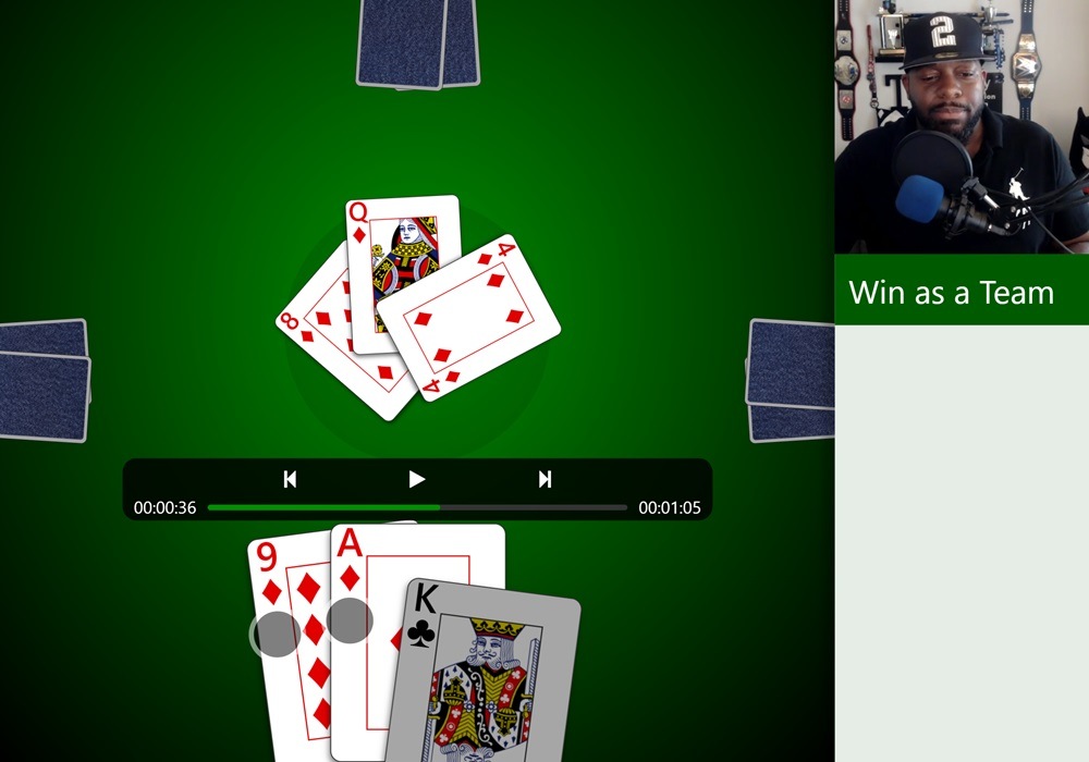 Screenshot of a Spades lesson in Trickster Cards. A video of Professor T is displayed in the top-right along with the lesson title of 'Win as a Team'. The game is showing playback controls as well as a partially played trick. The current player's partner is taking the trick and the current player has the choice to play higher or lower.